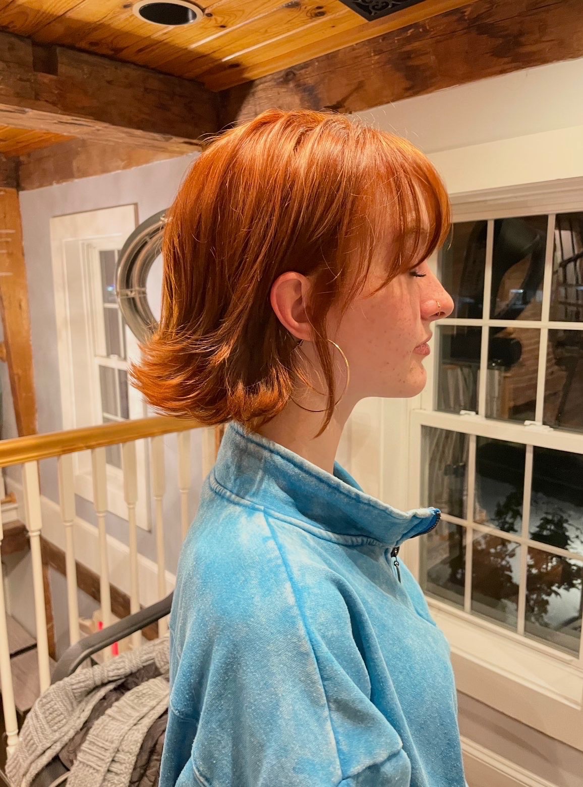 Side view of a copper layered bob with softly flipped ends and a sweeping fringe.