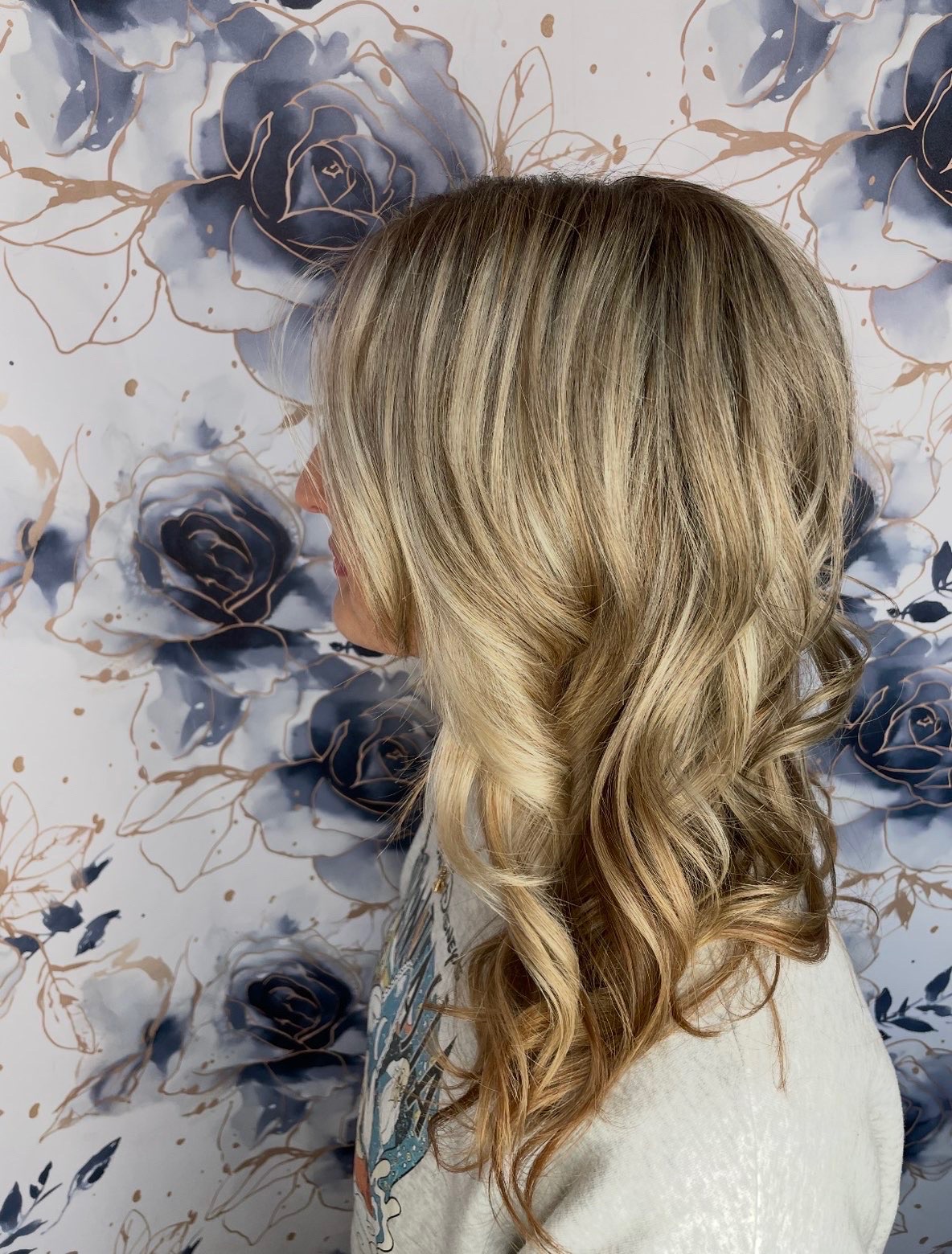 Side-back view of the same blonde finish showing blended ribbons and curled ends.