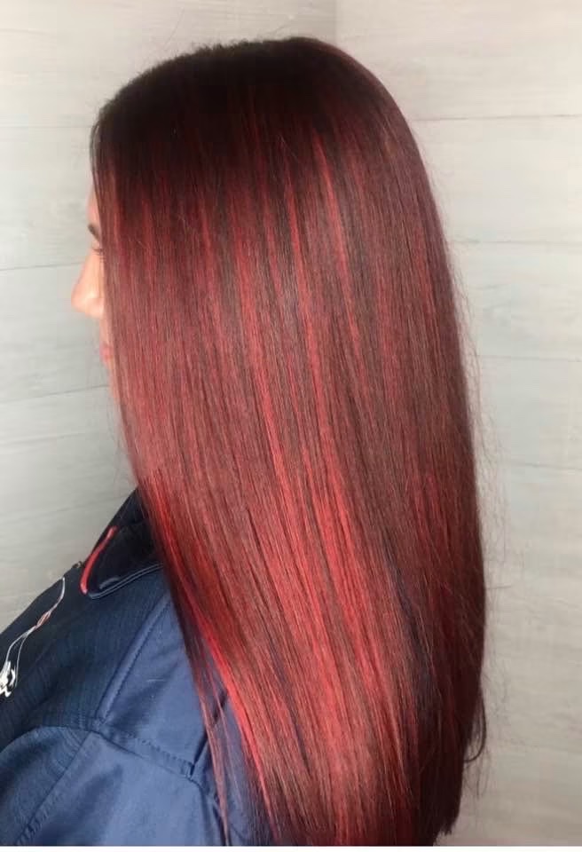 Side view of long, straight auburn-red hair with brighter red dimension.