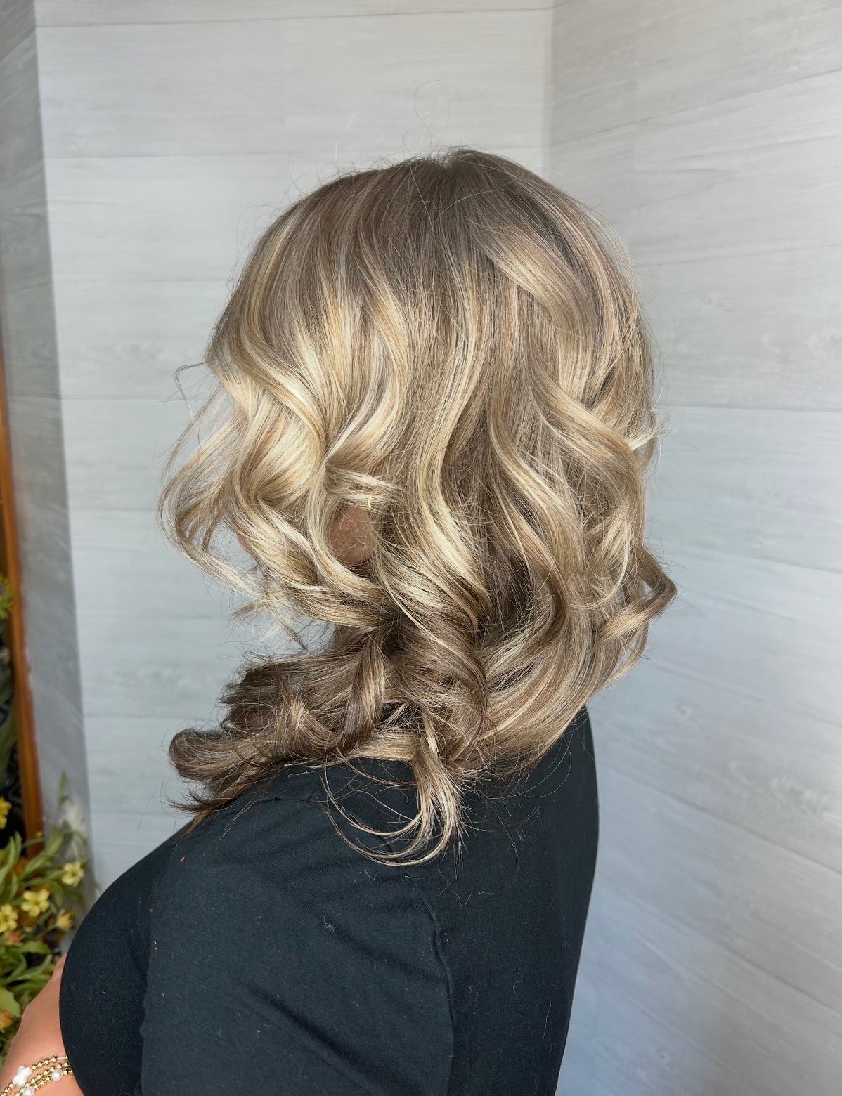 Back view of the same brunette hair showing blended highlights and loose curls.