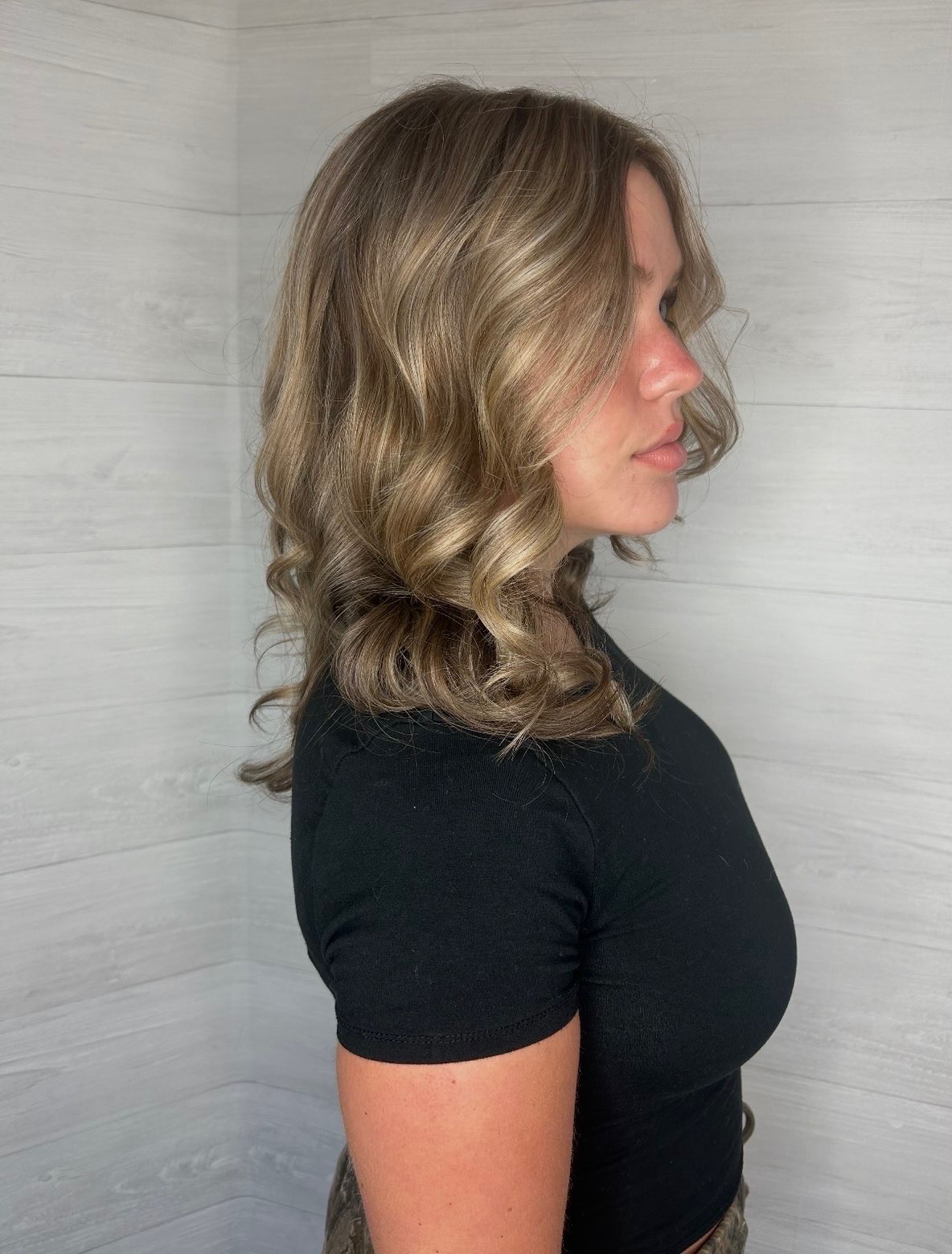 Profile view of softly curled brunette hair with lighter dimensional ribbons.