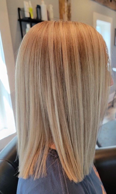 Side view of the same blunt blonde lob, straight and glossy with a soft golden root.