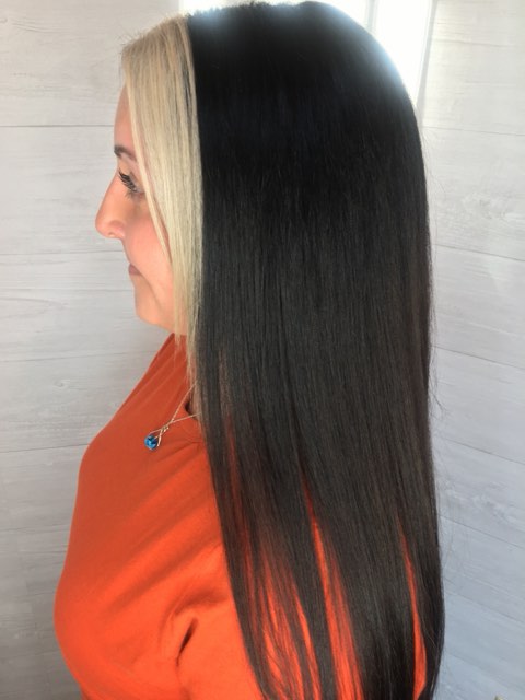 Profile view of long, straight black hair with a bright platinum section at the front.