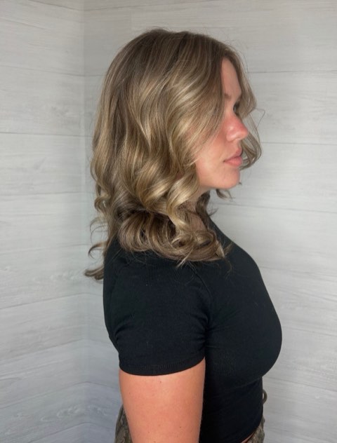 Profile view of softly curled brunette hair with lighter dimensional ribbons.